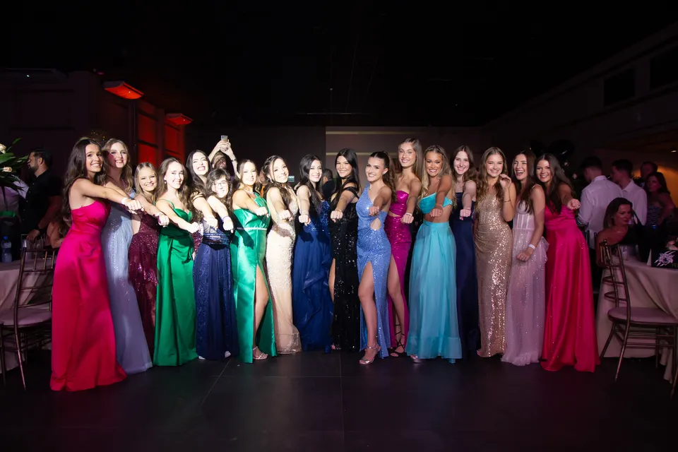 Formandas reunidas com vestidos de gala coloridos na festa