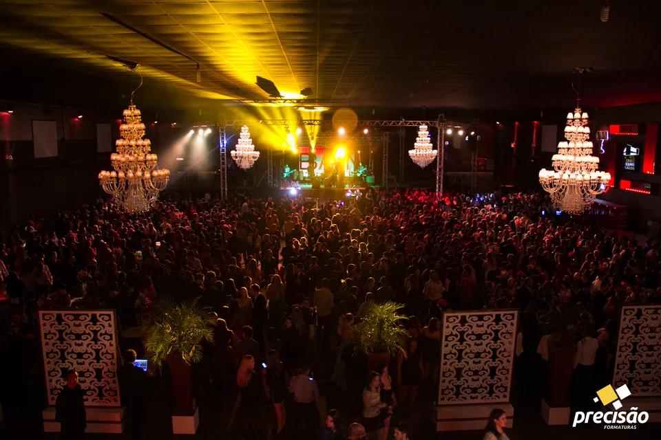 Vista panorâmica do baile com palco e lustres