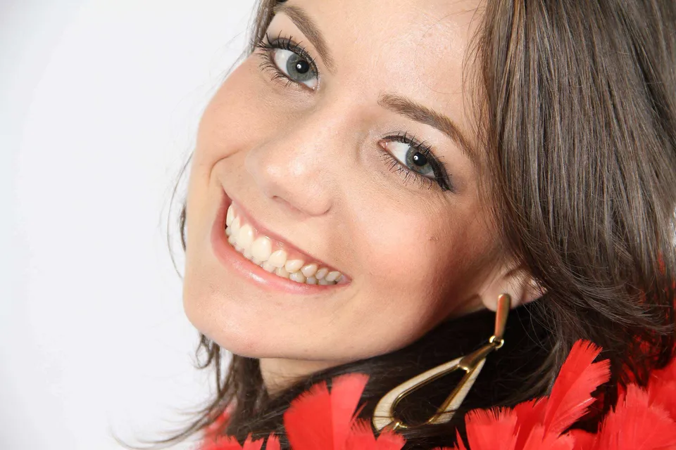 Retrato de Book com plumas vermelhas e sorriso em destaque