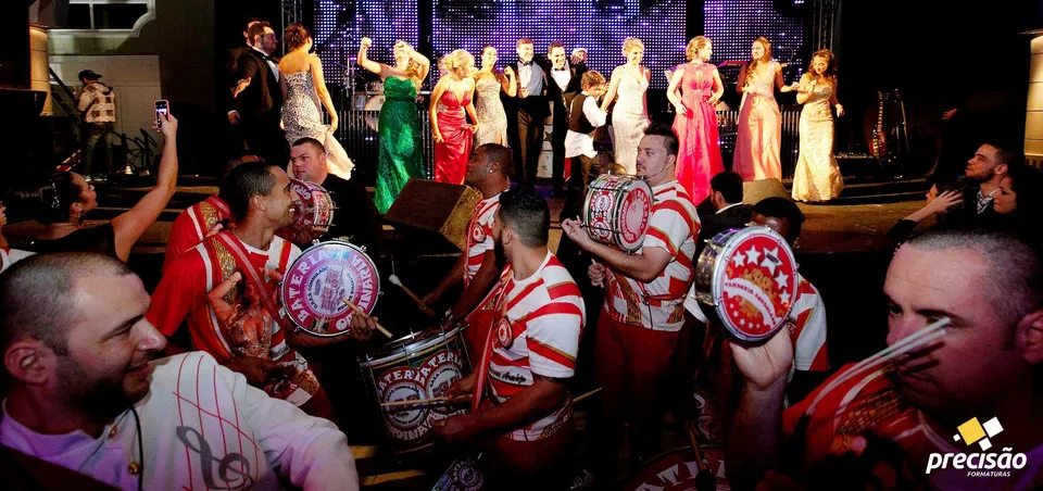 Percussionistas e convidados celebrando diante do palco