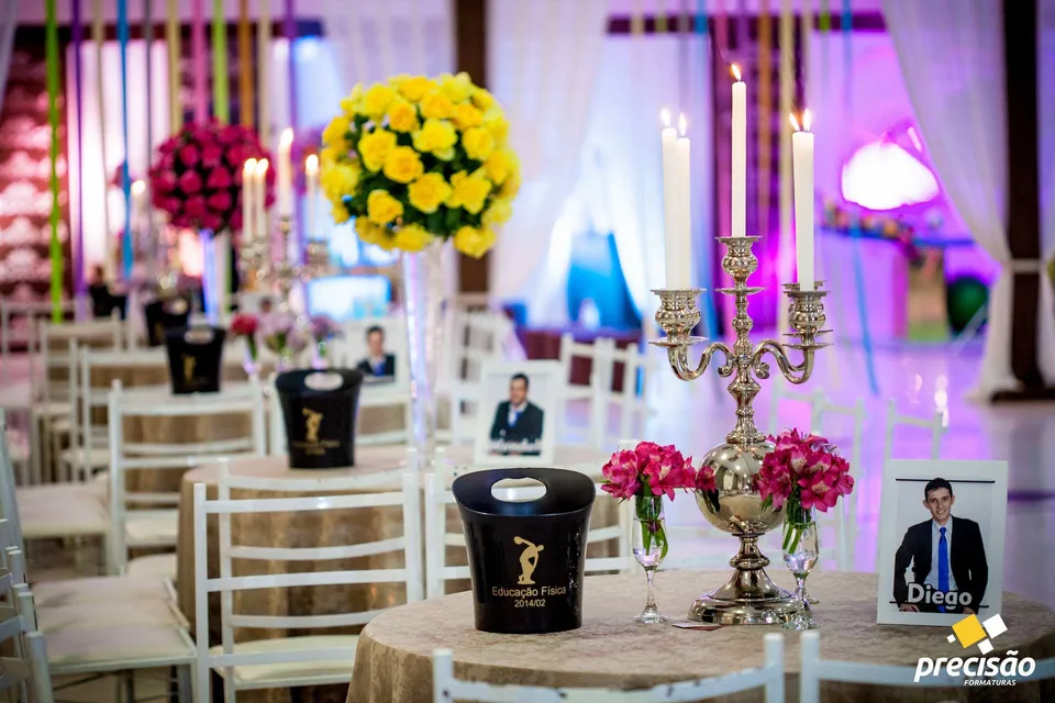 Mesa de formatura com candelabro prateado, flores e decoração personalizada
